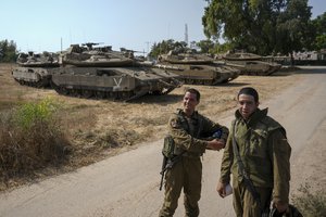 Israeli soldiers near their tanks in an area near the border with Gaza Strip, Friday, Aug. 5, 2022