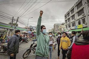 Protesters march through the streets during an anti-government demonstration in Mandalay, Myanmar, Tuesday, Dec. 7, 2021.