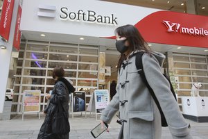 People walk by a SoftBank shop in Tokyo, Monday, Feb. 8, 2021.