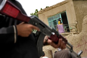 File - A Taliban fighter stands guard at the site of an explosion in front of a school, in Kabul, Afghanistan, Tuesday, April 19, 2022. An Afghan police spokesman says explosions targeting educational institutions in Kabul have killed at least six civilians and injured over 10 others.