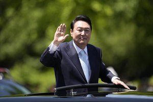 South Korea's new President Yoon Suk Yeol waves from a car after the Presidential Inauguration outside the National Assembly in Seoul, South Korea, Tuesday, May 10, 2022.