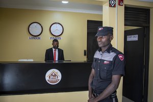 A security guard stands in the reception area of the Hope Hostel, which is one of the locations expected to house some of the asylum-seekers due to be sent from Britain to Rwanda, in the capital Kigali, Rwanda Friday, June 10, 2022. As Britain plans to send its first group of asylum-seekers to Rwanda amid outcries and legal challenges, some who came there from Libya under earlier arrangements with the United Nations say the new arrivals can expect a difficult time ahead.