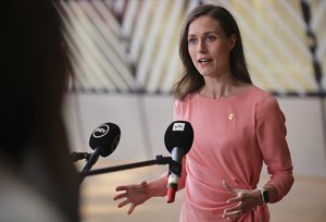 Finland's Prime Minister Sanna Marin speaks with the media as she arrives for an EU summit in Brussels, Thursday, June 23, 2022