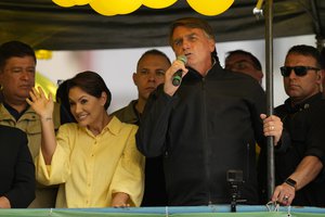 Brazilian President who is running for reelection, Jair Bolsonaro, speaks during a campaign rally as his wife Michelle waves, in Juiz de Fora, Minas Gerais state, Brazil, Tuesday, Aug. 16, 2022