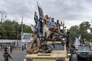 Taliban fighters celebrate one year since they seized the Afghan capital, Kabul, in front of the U.S. Embassy in Kabul, Afghanistan, Monday, Aug. 15, 2022.