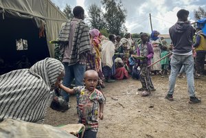 File - Displaced Amharas from different villages now controlled by Tigrayan forces in the North Gondar zone, queue to receive food at a kindergarten school housing the internally-displaced, in Debark, in the Amhara region of northern Ethiopia Wednesday, Aug. 25, 2021. As they bring war to other parts of Ethiopia such as the Amhara region, resurgent Tigray fighters face growing allegations that they are retaliating for the abuses their people suffered back home.