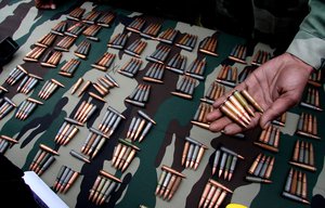 An Indian army soldier displays seized bullets during a news conference after a gun battle, in Srinagar March 25, 2009.