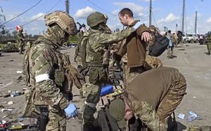 File - In this photo taken from video released by the Russian Defense Ministry on Friday, May 20, 2022, Russian servicemen frisk Ukrainian servicemen after they leaved the besieged Azovstal steel plant in Mariupol, in territory under the government of the Donetsk People's Republic, eastern Ukraine.