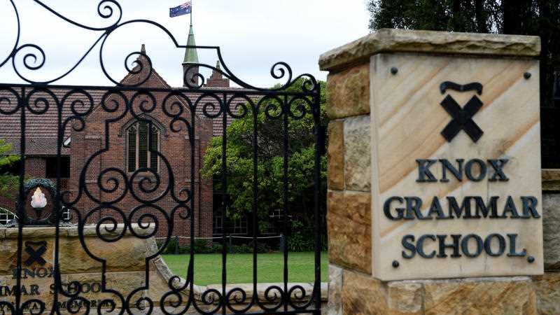 The front of Knox Grammar School with a metal gate and sign