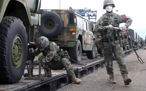 In this handout photo taken from video released by Russian Defense Ministry Press Service on Monday, Aug. 29, 2022, Chinese soldiers arrive to the Grodekovo railway station to participate in war games drills, in Grodekovo, Primorsky Krai, Russia