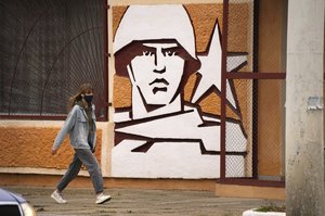 FILE - A woman walks past the Operational Group of Russian Forces headquarters in Tiraspol, the capital of the breakaway region of Transnistria, a disputed territory unrecognized by the international community, in Moldova, Nov. 1, 2021.