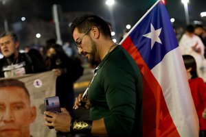 An opponent of the new Constitution listens to the partial results of a plebiscite on whether the new Constitution will replace the current Magna Carta imposed by a military dictatorship 41 years ago, in Santiago, Chile, Sunday, Sept. 4, 2022