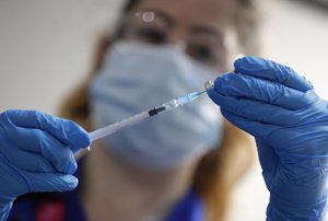 A nurse prepares a shot of the Pfizer-BioNTech COVID-19 vaccine at Guy's Hospital in London, Tuesday, Dec. 8, 2020