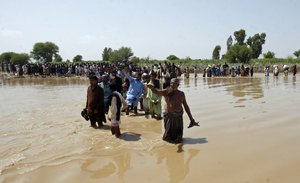 Victims of unprecedented flooding from monsoon rains line up to receive relief aid organized by the Edhi Foundation, in the Ghotki District of Sindh Pakistan, Wednesday, Sept. 7, 2022.