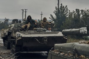 Ukrainian military vehicles move on the road in the freed territory in the Kharkiv region, Ukraine, Monday, Sept. 12, 2022