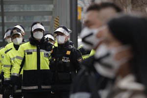 South Korean police officers wearing face masks as a precaution against the coronavirus, stand in Seoul, South Korea, Friday, Feb. 5, 2021