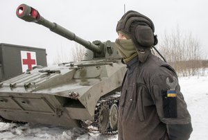 A Ukrainian soldier trains during military drills close to Kharkiv, Ukraine, Thursday, Feb. 10, 2022. Britain's top diplomat has urged Russia to take the path of diplomacy even as thousands of Russian troops engaged in sweeping maneuvers in Belarus as part of a military buildup near Ukraine.