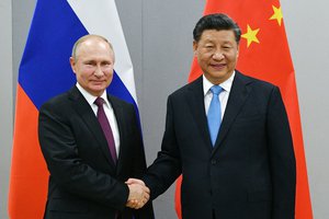 Russian President Vladimir Putin, left, and China's President Xi Jinping shake hands prior to their talks on the sideline of the 11th edition of the BRICS Summit, in Brasilia, Brazil in Nov. 12, 2019