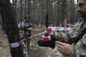 Oleg Kotenko, the Commissioner for Issues of Missing Persons under Special Circumstances looks at the unidentified graves of civilians and Ukrainian soldiers in the recently retaken area of Izium, Ukraine, Thursday, Sept. 15, 2022 who had been killed by Russian forces near the beginning of the war