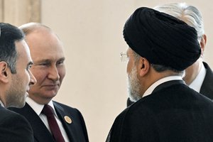 FILE - Russian President Vladimir Putin, left, speaks to Iran's President Ebrahim Raisi, back to a camera, on the sideline of the summit of Caspian Sea littoral states in Ashgabat, Turkmenistan, on June 29, 2022.