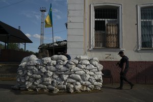 A member of the State Emergency Service of Ukraine enters in the basement of the train station fortified with sand bags that, according to Ukrainian authorities, was used as an interrogation room during the Russian occupation in the retaken village of Kozacha Lopan, Ukraine, Sunday, Sept. 18, 2022