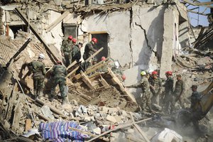 Rescuers work at the scene of damage after shelling by Armenian's artillery during fighting over the separatist region of Nagorno-Karabakh, in Ganja, Azerbaijan, Sunday, Oct. 11, 2020.