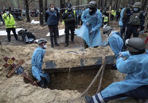 Emergency workers move a body during the exhumation in the recently retaken area of Izium, Ukraine, Friday, Sept. 16, 2022