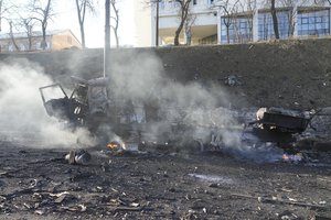 Debris of a burning military truck is seen on a street in Kyiv, Ukraine, Saturday, Feb. 26, 2022