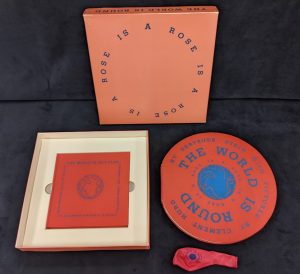 Photo of the full box set of the 1986 Arion Press edition of "The World Is Round" including the box, the book, a companion book "The World Is Not Flat," and a balloon.