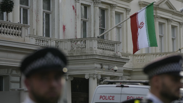 Police stand guard outside the Iranian Embassy in London, which has been hit by paint from protesters.