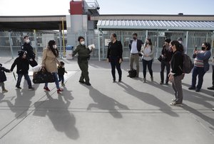 US Customs and Border Protection officers and agents process a small group of asylum-seekers who have active applications under the Migrant Protection Protocols at the Paso del Norte Port of Entry in El Paso, Texas, February 26, 2021