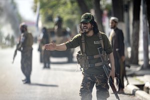 Taliban fighters stand guard at the explosion site, near a mosque, in Kabul, Afghanistan, Friday, Sept. 23, 2022