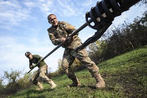 Ukrainian soldiers clean the muzzle of Ukrainian howitzer D-30 near Siversk, Donetsk region, Ukraine, Saturday, Oct. 1, 2022