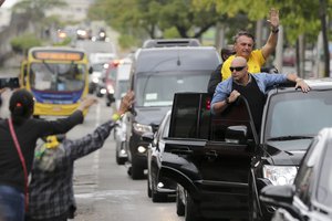 Brazilian President Jair Bolsonaro, back right, who is running for another term, waves to followers in the general election in Rio de Janeiro, Brazil, Sunday, Oct. 2, 2022