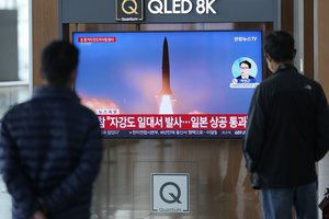 A TV screen showing a news program reporting about North Korea's missile launch with file image, is seen at the Seoul Railway Station in Seoul, South Korea, Tuesday, Oct. 4, 2022