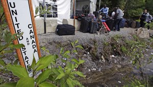 Migrants stack their luggage outside a makeshift police station after crossing illegally into Canada at the end of Roxham Road in Champlain, N.Y., while heading to an unofficial border station across from Saint-Bernard-de-Lacolle, Quebec, Monday, Aug. 7, 2017.