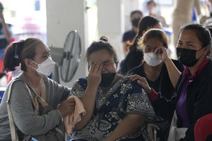 Relative of victims cry outside the Childcenter Uthai Sawan that was attacked by a lone assailant in the rural town of Uthai Sawan, north eastern Thailand, early Friday, Oct. 7, 2022