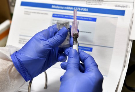 In this July 27, 2020, file photo, Nurse Kathe Olmstead prepares a shot that is part of a possible COVID-19 vaccine, developed by the National Institutes of Health and Moderna Inc., in Binghamton, N.Y.