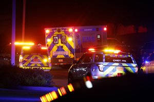 An ambulance believed to be carrying a shooting suspect arrives at Wake Medical Center Emergeny Room in Raleigh, N.C., Thursday, Oct. 13, 2022 surrounded by police