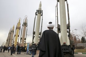 FILE - In this Feb. 3, 2019 file photo, an Iranian clergyman looks at domestically built surface to surface missiles displayed by the Revolutionary Guard in a military show marking the 40th anniversary of the Islamic Revolution, at Imam Khomeini Grand Mosque in Tehran, Iran.