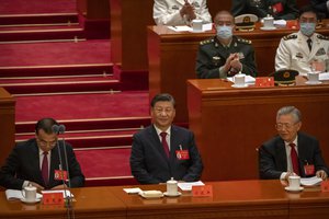 China's President Xi Jinping, center, sits after giving a speech during the opening ceremony of the 20th National Congress of China's ruling Communist Party in Beijing, Sunday, Oct. 16, 2022