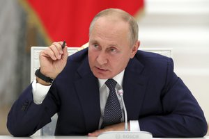 Russian President Vladimir Putin gestures while speaking during a meeting with employees of the nuclear industry on their professional holiday, Nuclear Industry Worker's Day, at the Kremlin in Moscow, Russia, on Sept. 23, 2020