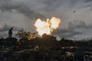 A Ukrainian serviceman reacts as a self-propelled artillery vehicle fires near Bakhmut, Donetsk region, Ukraine, Saturday, Oct. 22, 2022.