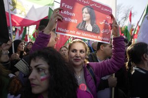 A woman holds a portrait of Mahsa Amini during a protest against the Iranian regime, in Berlin, Germany, Saturday, Oct. 22, 2022