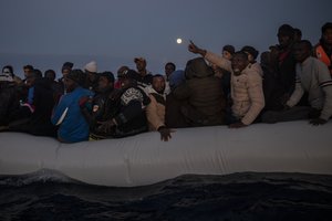 Migrants and refugees from different African nationalities react on an overcrowded wooden boat, as aid workers of the Spanish NGO Open Arms approach them in the Mediterranean Sea, international waters, off the Libyan coast, in this Friday, Jan. 10, 2020, file photo. When Libyan security forces rescued her earlier this year, a young Somali woman thought it would be the end of her suffering. For more than two years, she had been imprisoned and sexually abused by human traffickers notorious for extorting, torturing and assaulting migrants like her trying to reach Europe.