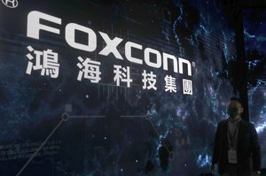 A man walks past the Foxconn logo during the 2022 Hon Hai Tech Day (HHTD 22) at the Nangang Exhibition Center in Taipei, Taiwan, Tuesday, Oct. 18, 2022.