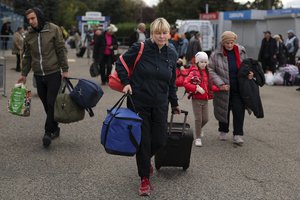 Evacuees from Kherson gather upon their arrival at the railway station in Anapa, southern Russia, Tuesday, Oct. 25, 2022