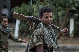 File - Fighters loyal to the Tigray People's Liberation Front (TPLF) walk along a street in the town of Hawzen, then controlled by the group, in the Tigray region of northern Ethiopia on May 7, 2021. Ethiopia's warring sides have formally agreed to a permanent cessation of hostilities in a 2-year conflict, negotiators for the parties announced Wednesday, Nov. 2, 2022.