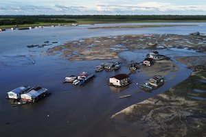 Houseboats sit amid drought-impacted land near the Solimões River, in Tefe, Amazonas state, Brazil, Wednesday, Oct. 19, 2022