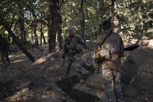 Ukrainian servicemen check the trenches dug by Russian soldiers in a retaken area in Kherson region, Ukraine, on Oct. 12, 2022